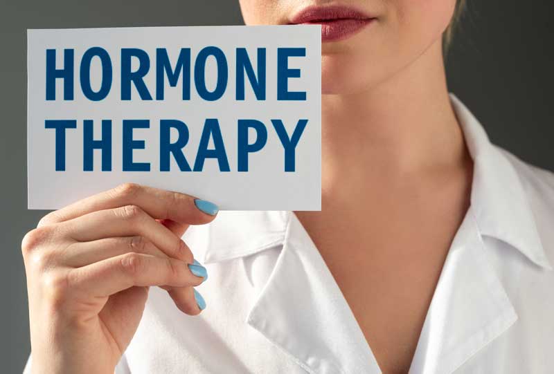 doctor in a white coat holding a hormone therapy sign