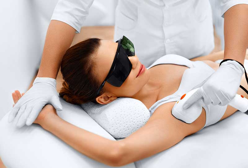 A woman getting laser hair removal on her underarm