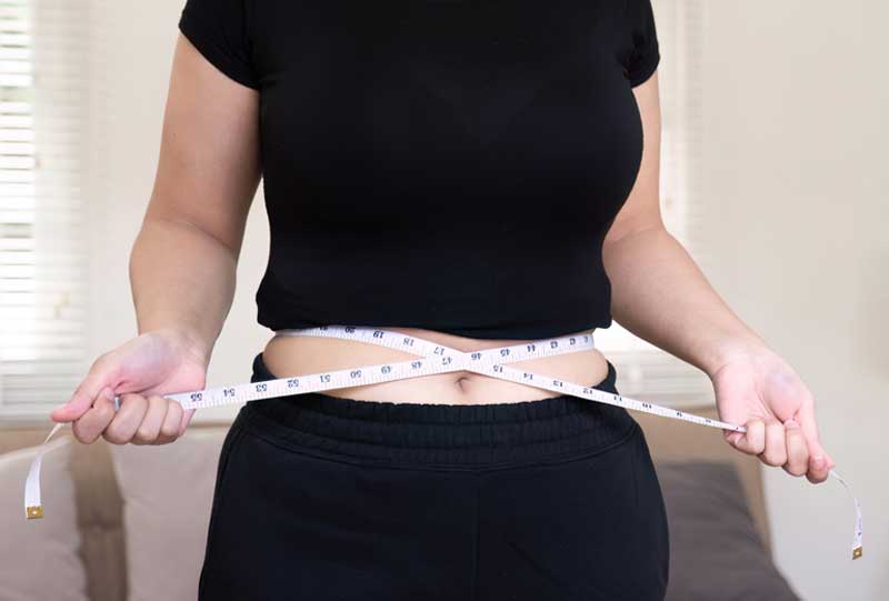 woman with a tape measure wrapped around her waist